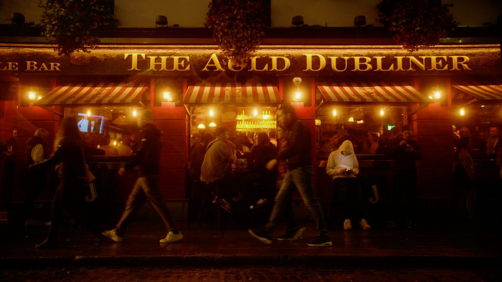 Night shot of partygoers walking past The Auld Dubliner pub in Temple Bar, Dublin, Ireland