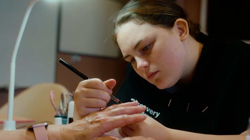 Young woman performing a manicure during a beauty course at Darndale’s Discovery Community Training Centre