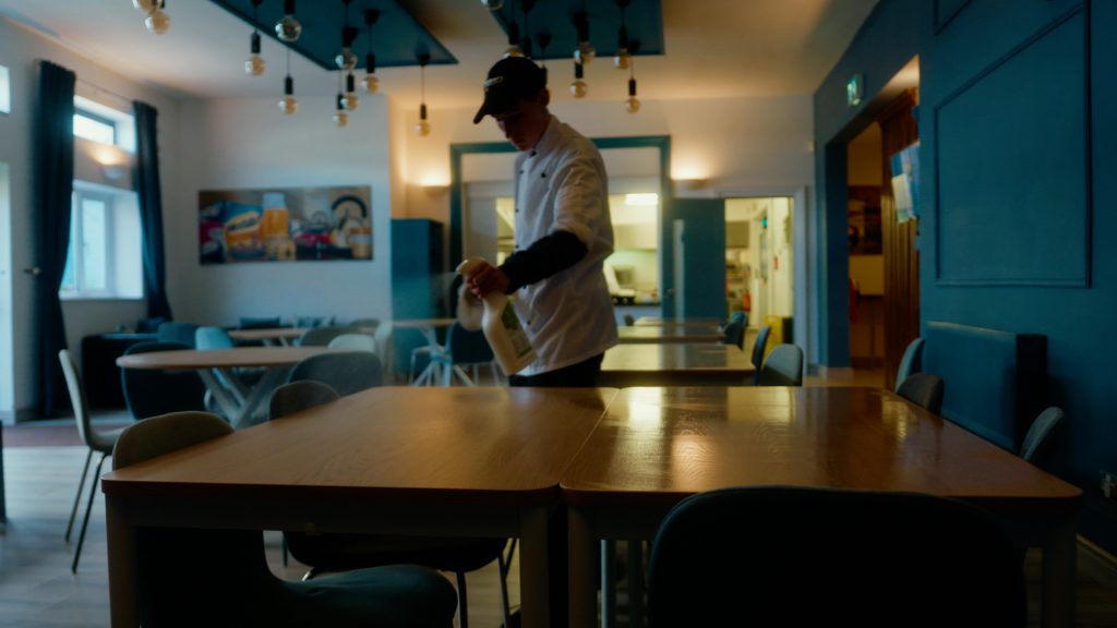 Student wiping down a table in the canteen at Darndale Discovery Centre as part of a second-chance education program