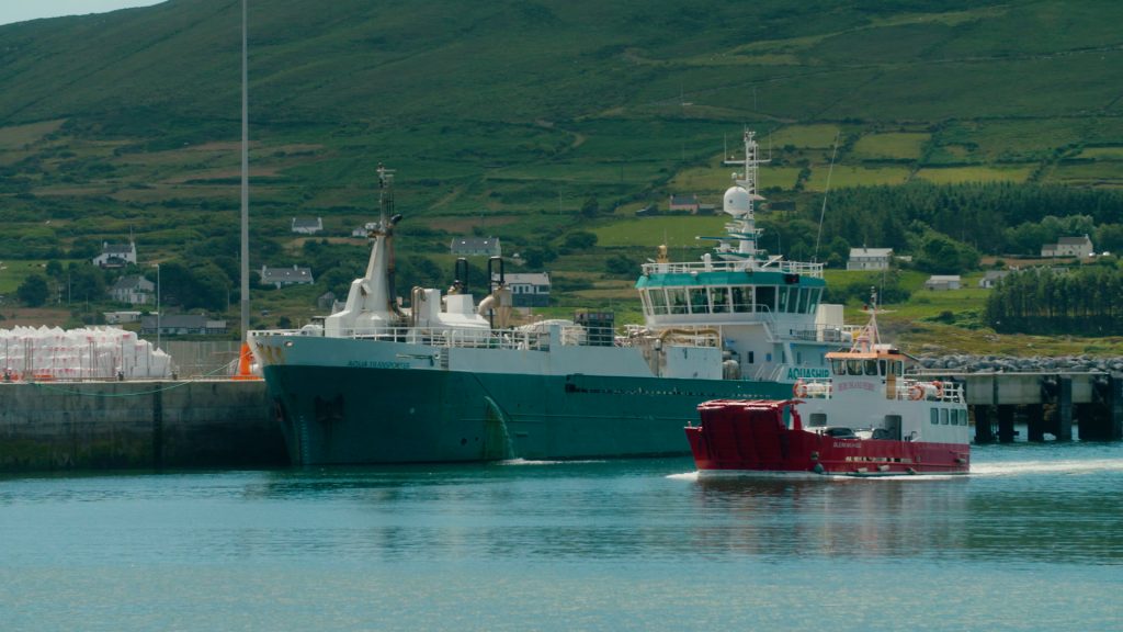 Ferry crossing Castletown Bere Bay, with scenic coastline in the background