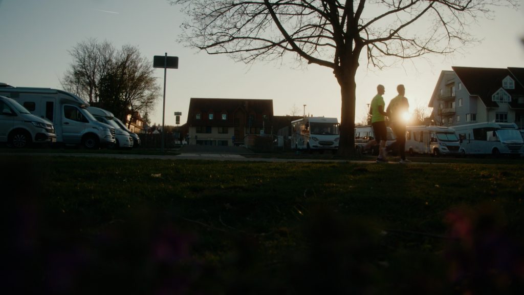 Wide shot of two runners silhouetted by the setting sun