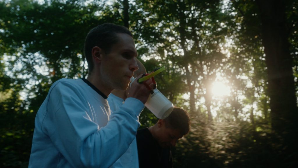 Backlit medium shot of blind athlete walking toward starting position in a forest