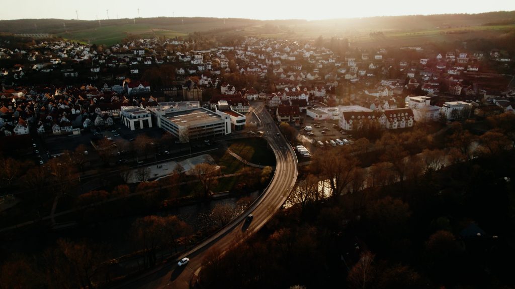 Aerial view of historic town center and rooftops in Melsungen, Germany, captured by drone during golden hour