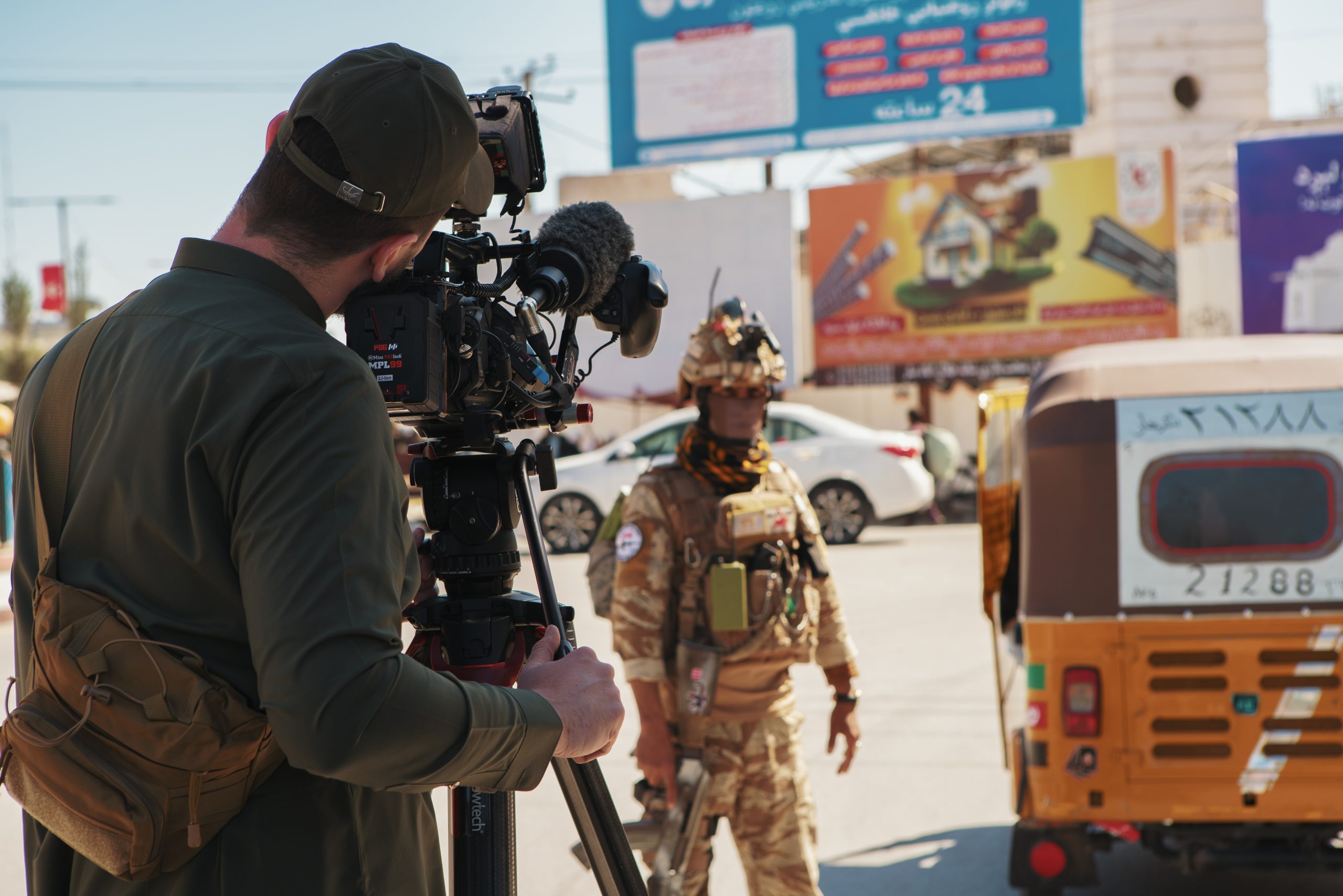 Killian Bayer capturing footage of a Taliban soldier manning a checkpoint in Jalalabad, Nangarhar province, Afghanistan, amid congested passing traffic.