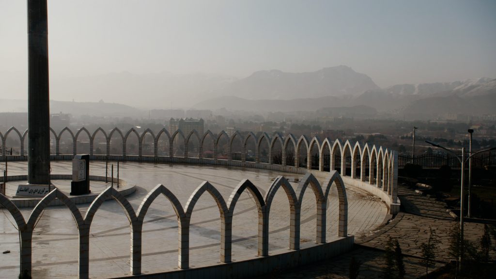 Wide shot of Wazir Akbar Khan hill overlooking Kabul city surrounded by mountains