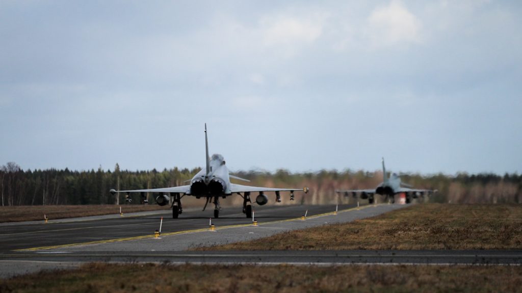 ear view of two NATO Eurofighter jets taxiing to the runway, preparing for takeoff