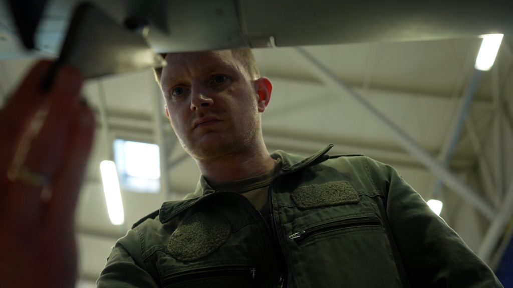 Mechanic examining flight instruments in the cockpit of Eurofighter jet during maintenance check