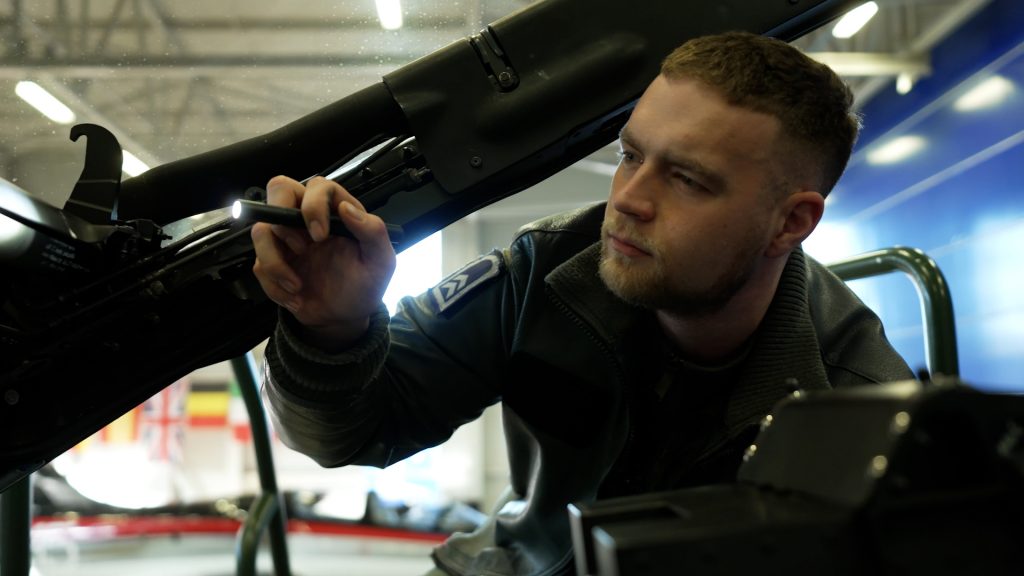 Mechanic with flashlight checking Eurofighter cockpit during maintenance
