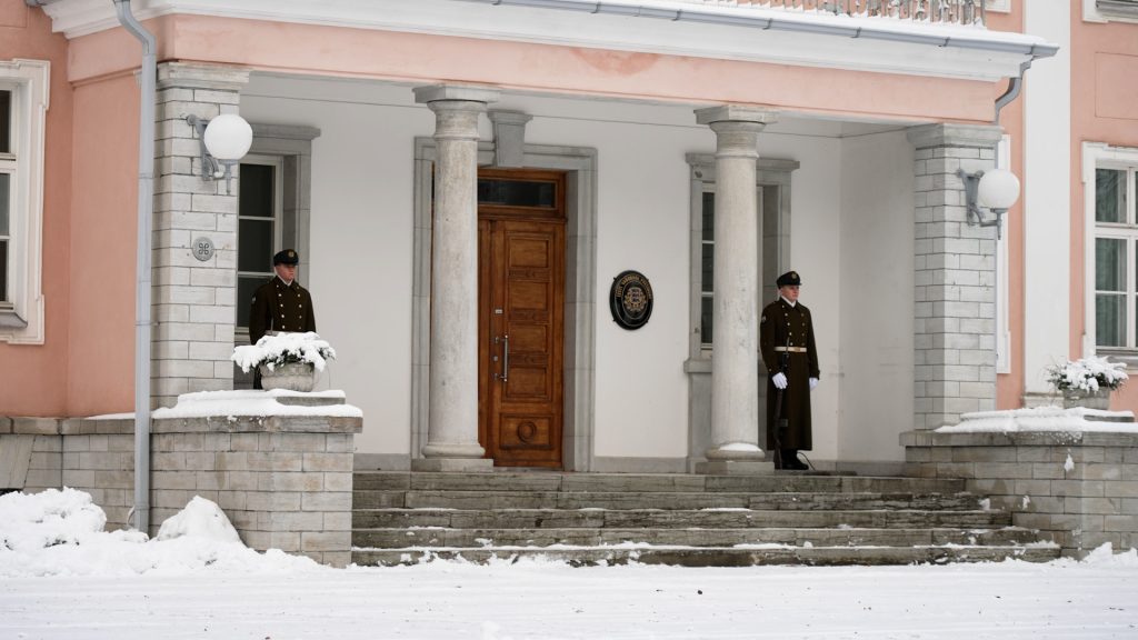 Two Estonian soldiers in ceremonial uniforms standing guard at a building entrance in Tallinn