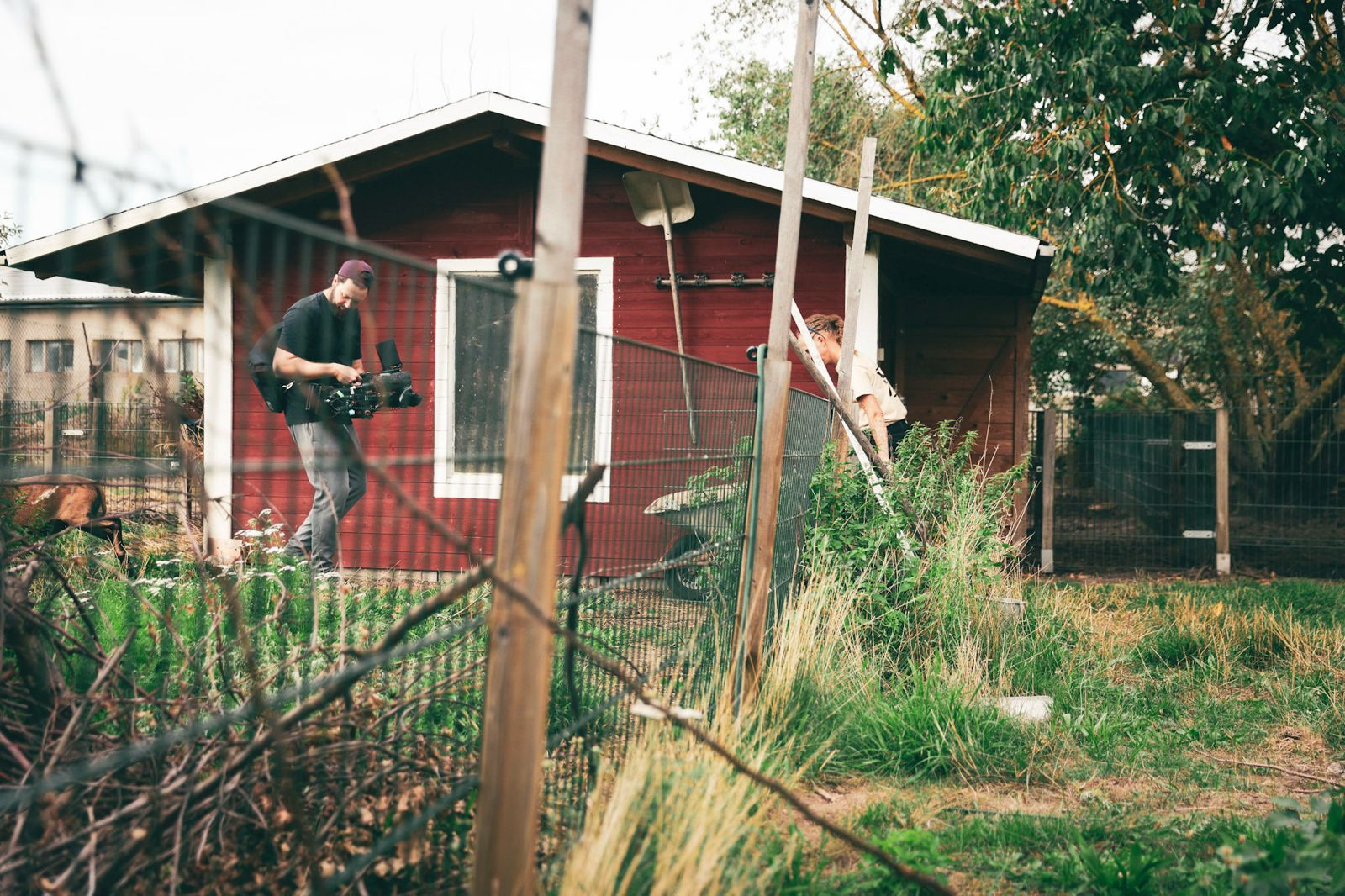 BTS image of Killian Bayer capturing dynamic handheld footage from the hip, positioned within the center of the unfolding scene.